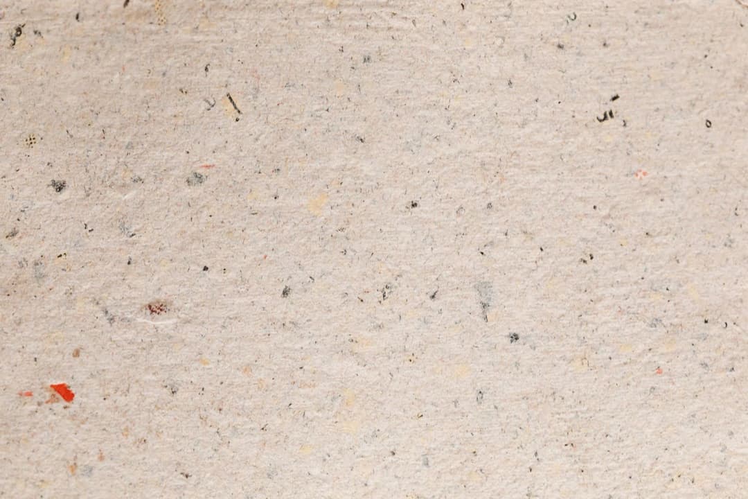 Handmade paper made from recycled scraps, with flecks of the original paper still showing